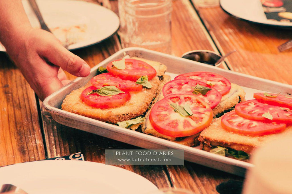 plant_based_disn_in_a_baking_tray_topped_with_tomatoes_being_served