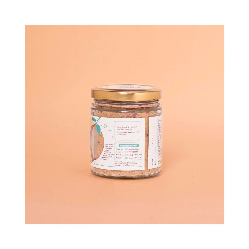 Jar of Nattier Chai Masala with usage label on a peach background