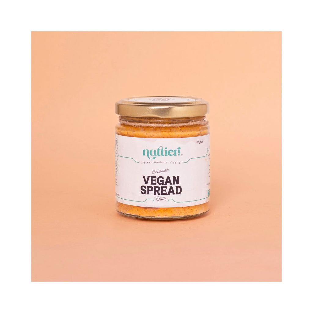 Jar of vegan chilli spread with white label on peach background