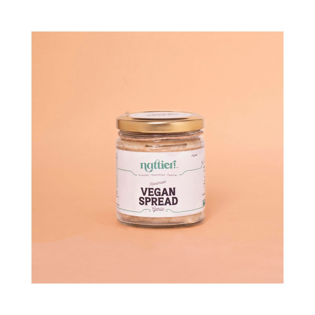 Jar of vegan spread with a gold lid on a peach background