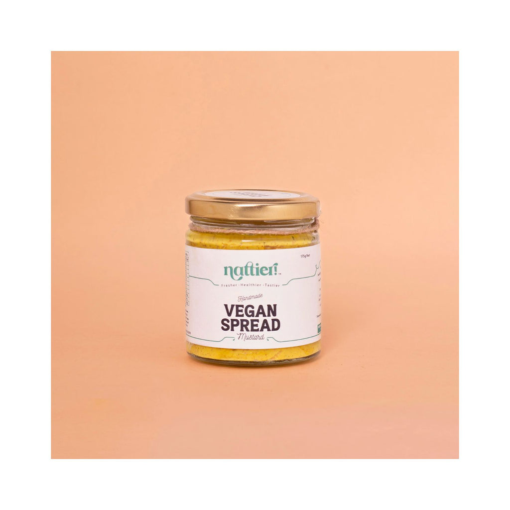 Jar of vegan mustard spread with a white label on a peach background