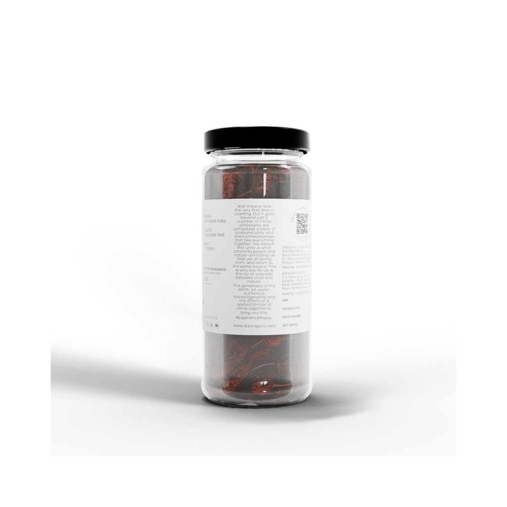 Jar of IKAI natural bhut jolokia with black lid containing red and white items on a white background with info about IKAI