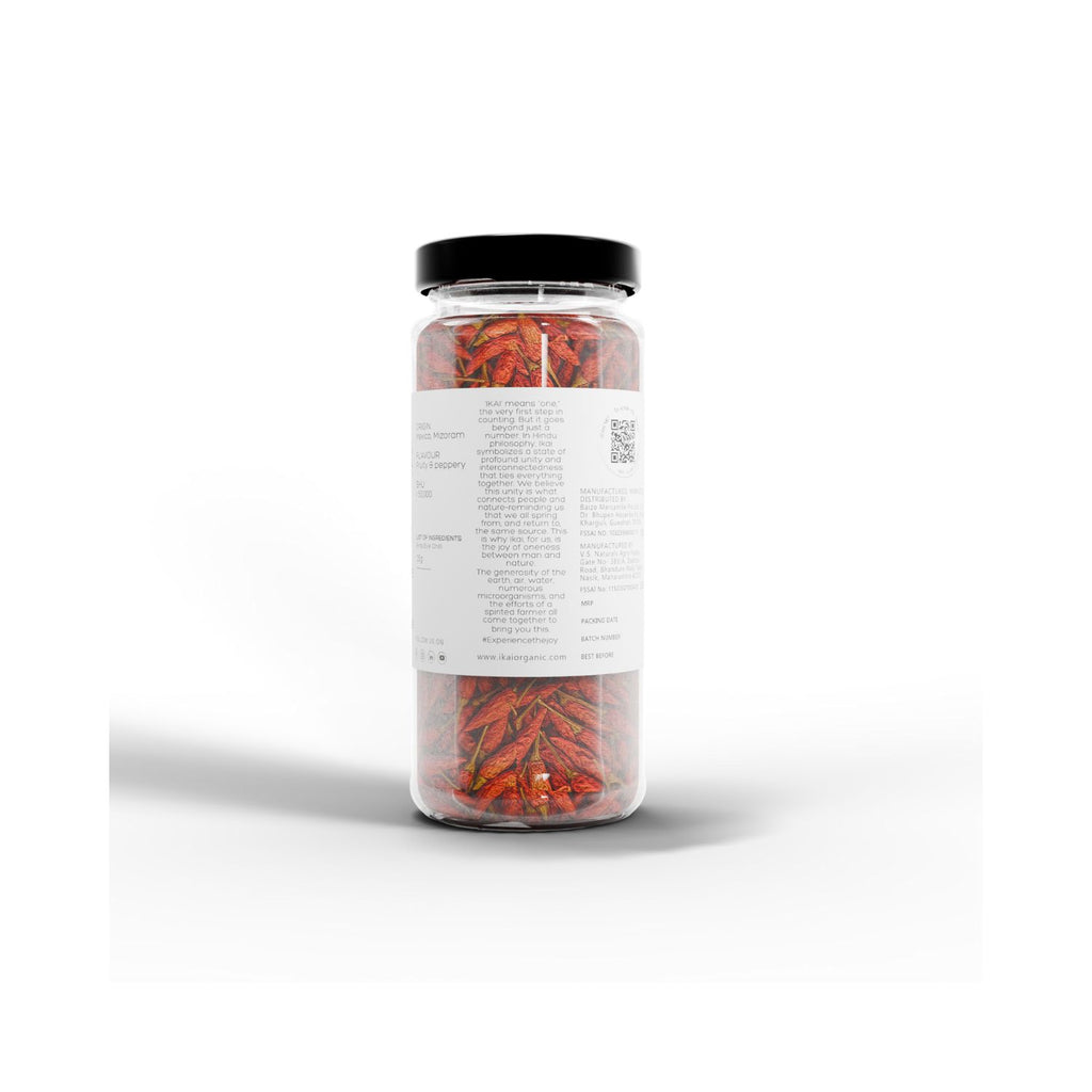 Jar of IKAI natural bird's eye chilli peppers with a black lid on a white background showing info of IKAI origins