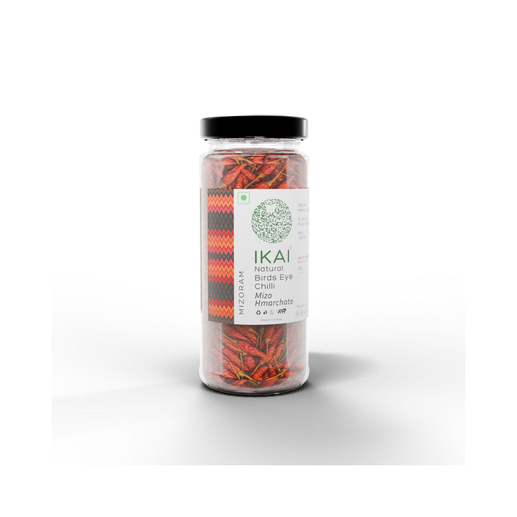 Jar of IKAI natural bird's eye chilli peppers on a white background at an angle