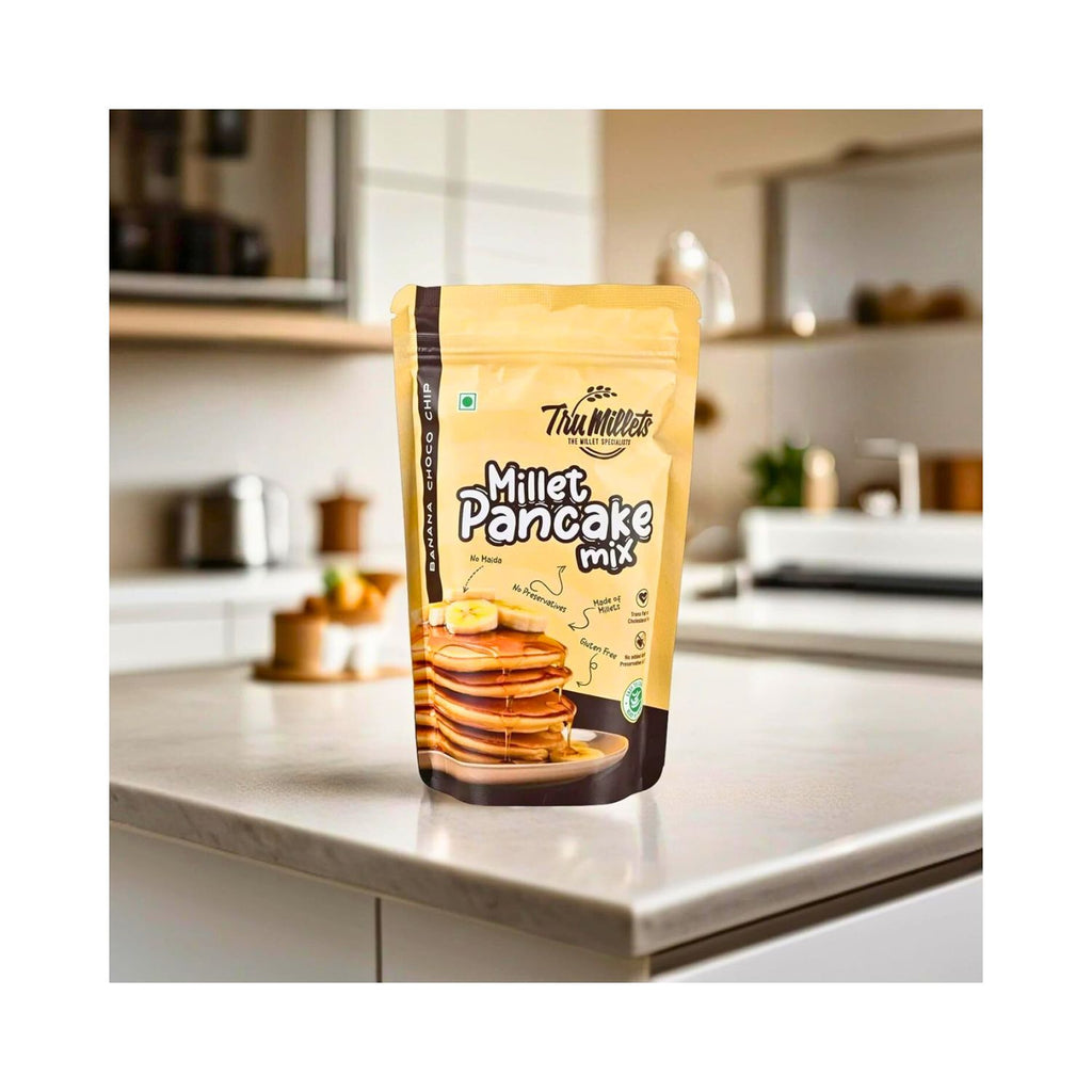 tru_millets_millet_banana_chocochip_pancake_mix_pack_of_3_450g_pack_front_on_kitchen_table